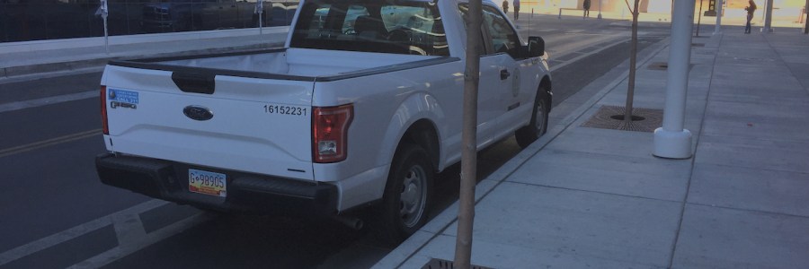 Albuquerque city planning department pickup, parked in a bike lane next to a "no parking bike lane" sign